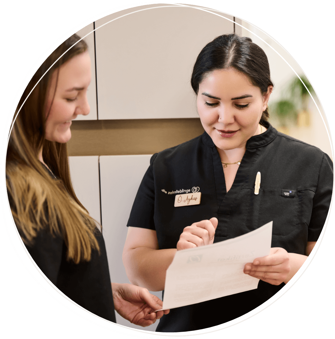 Zwei Mitarbeiterinnen der Zahnarztpraxis zahnlieblinge in Nürnberg besprechen die Behandlung einer Patientin