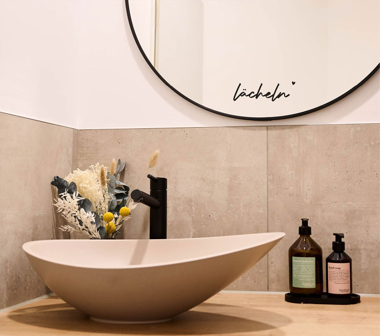 Im modernen, hellen und gemütlichen Badezimmer der Zahnarztpraxis zahnlieblinge fordert ein Schriftzug auf dem Spiegel zum Lächeln auf