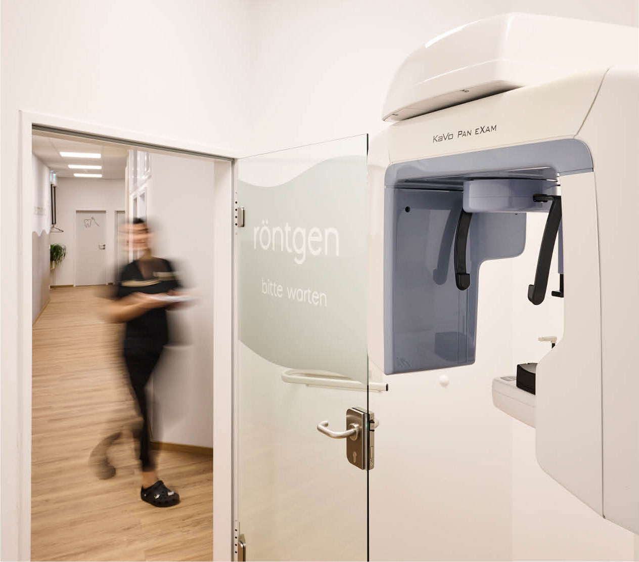 Eine Mitarbeiterin der Nürnberger Zahnarztpraxis zahnlieblinge huscht am Röntgenraum vorbei